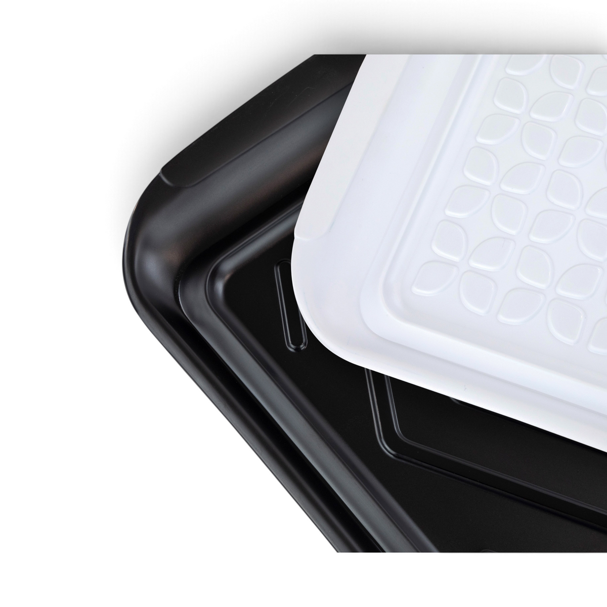 Three Prep and Serve BBQ Trays are stacked diagonally: two black with smooth surfaces underneath, and a white one with a textured geometric leaf pattern on top—ideal for grill masters to prevent contamination while serving.