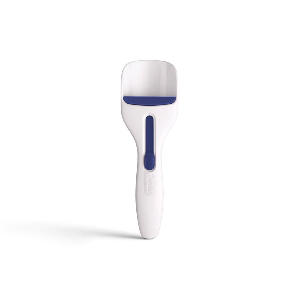 The Cupcake Scoop is a white handheld tool with a blue rubber strip across the scoop and a blue slider on the handle, perfect for baking cupcakes or removing pet hair.