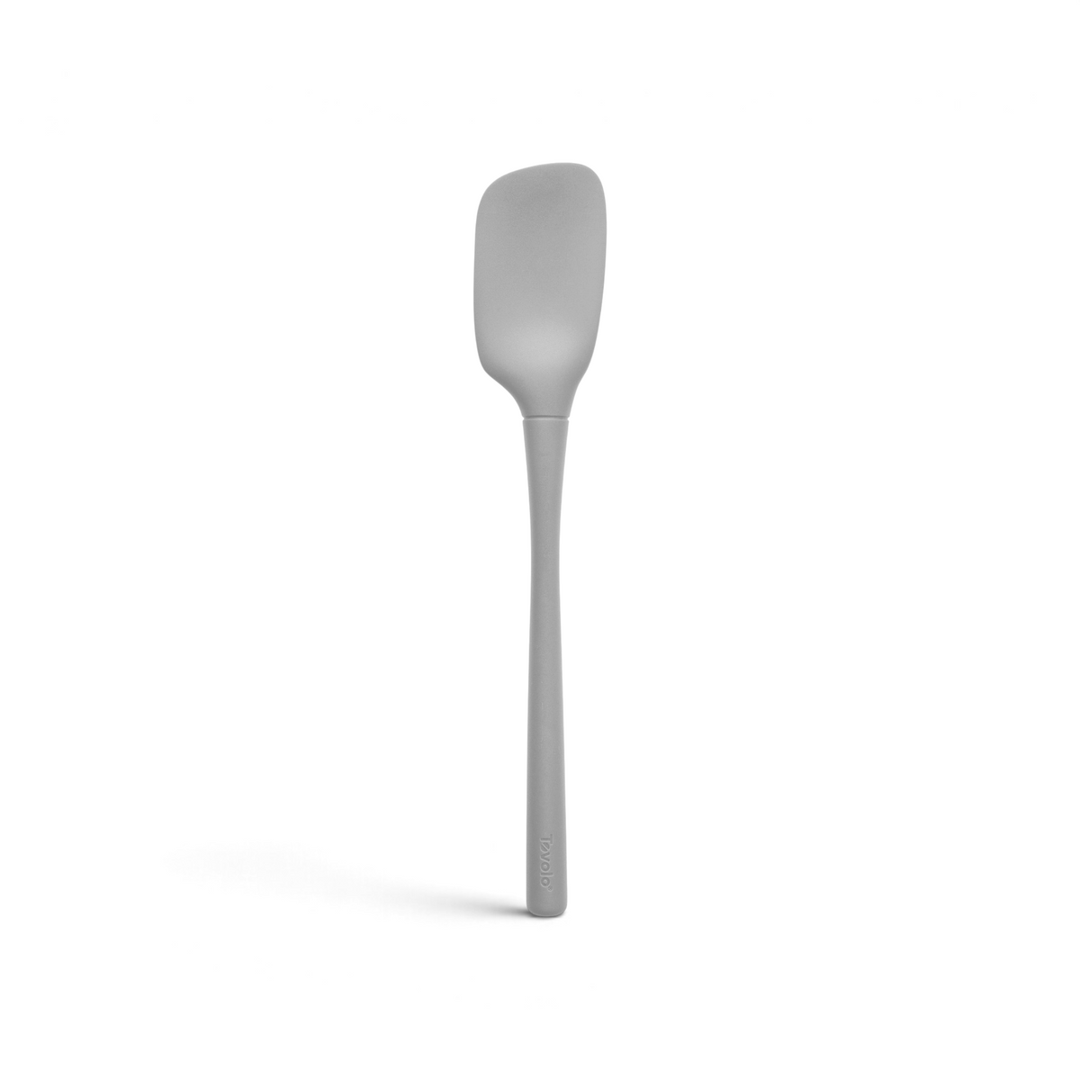 The tovolo Flex-Core Silicone Spoonula is shown against a white background, featuring a gray color, long handle, and a broad, flat, slightly curved silicone blade.