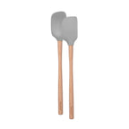 The Flex-Core Mini Spat + Spoonula set includes two heat-resistant kitchen utensils with light wooden handles and gray silicone heads—one a mini spatula and the other a spoonula—displayed side by side on a white background.