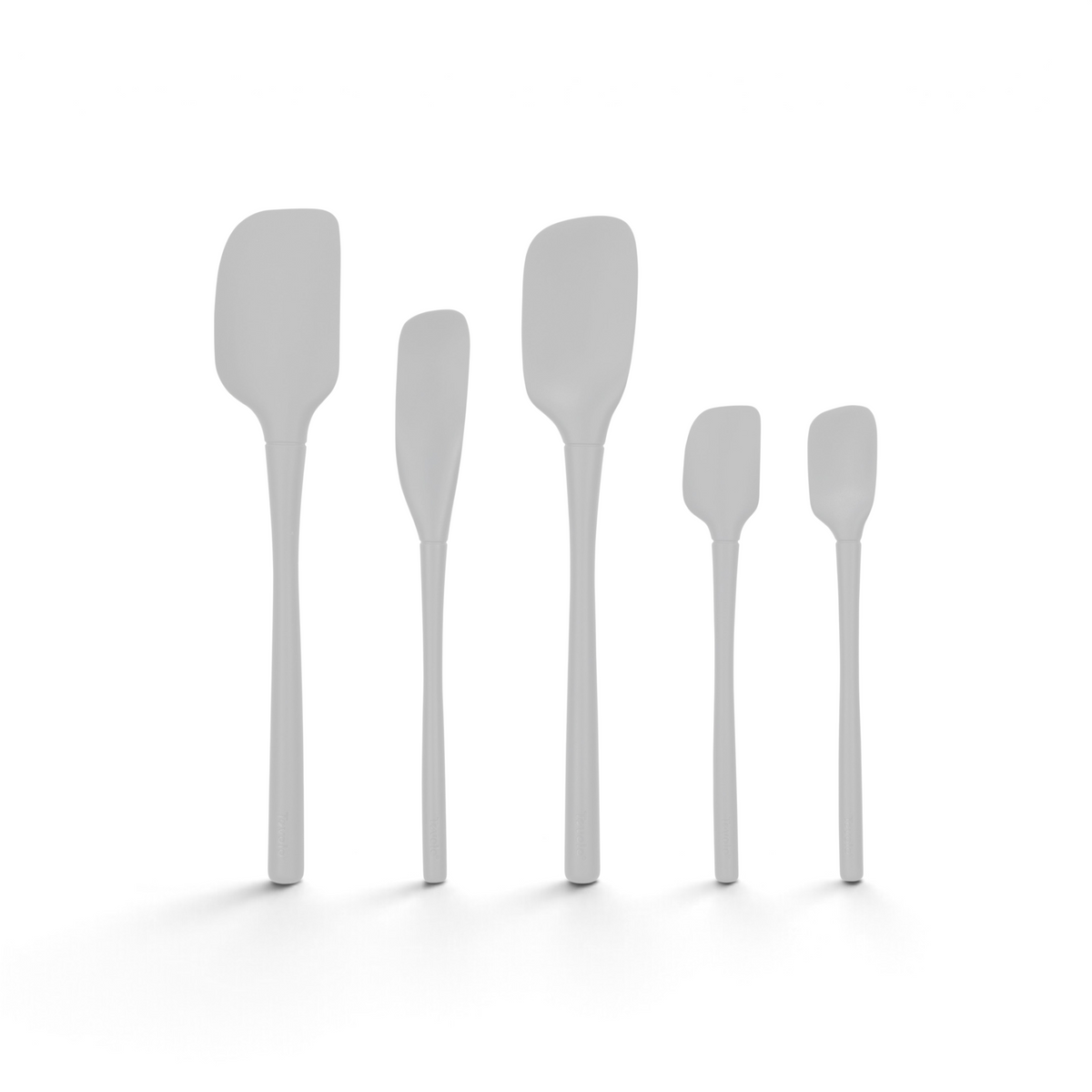 Five Flex-Core All-Silicone Spatula Set pieces, including a Jar Scraper and Classic Spatula, stand upright in a row. Each features a unique blade shape and handle length, shown against a white background.