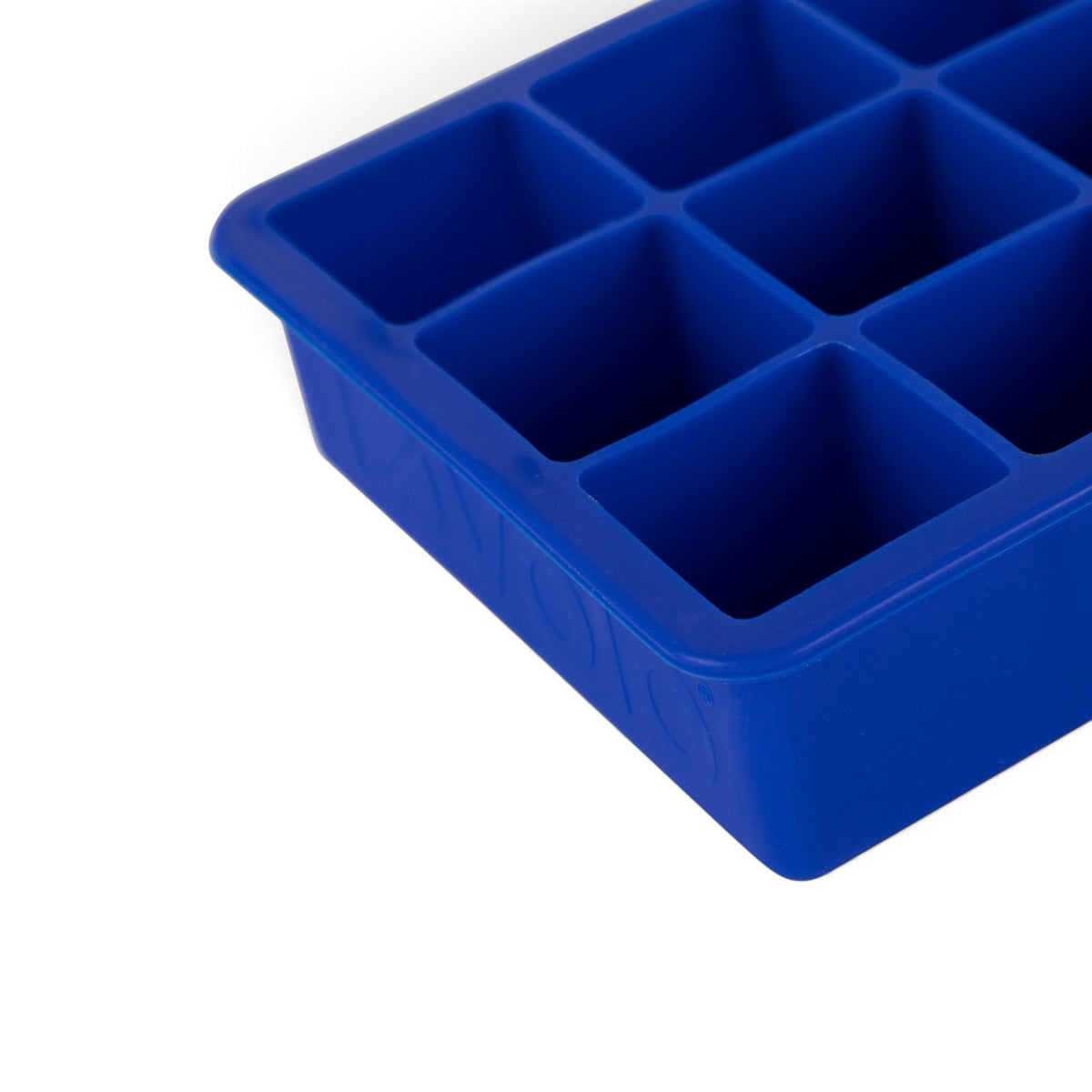 Close-up of tovolo Perfect Cube Silicone Ice Molds (Set of 2), featuring blue food-grade silicone with square compartments, angled on a white background for long-lasting ice.