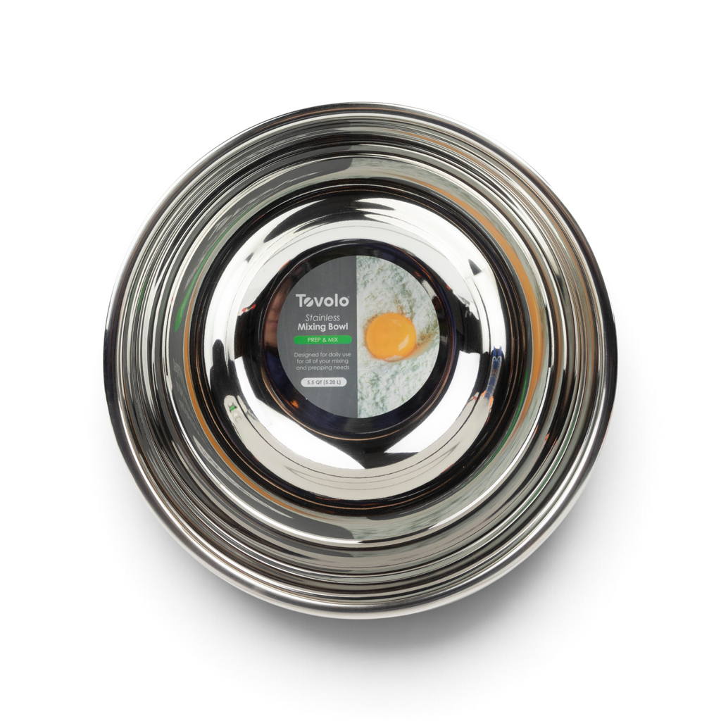 A shiny, stainless steel mixing bowl from tovolo’s Stainless Steel Mixing Bowl Set is shown from above. Its label displays a cracked egg and flour mixture, highlighting it as an easy-pour bowl ideal for any kitchen task.