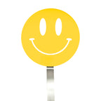 A yellow smiley face sign with a wide, curved smile and oval eyes is mounted on a silver pole, resembling the cheerful design of the Spatulart Flex Turner kitchen tool, which is safe for use with nonstick skillets.