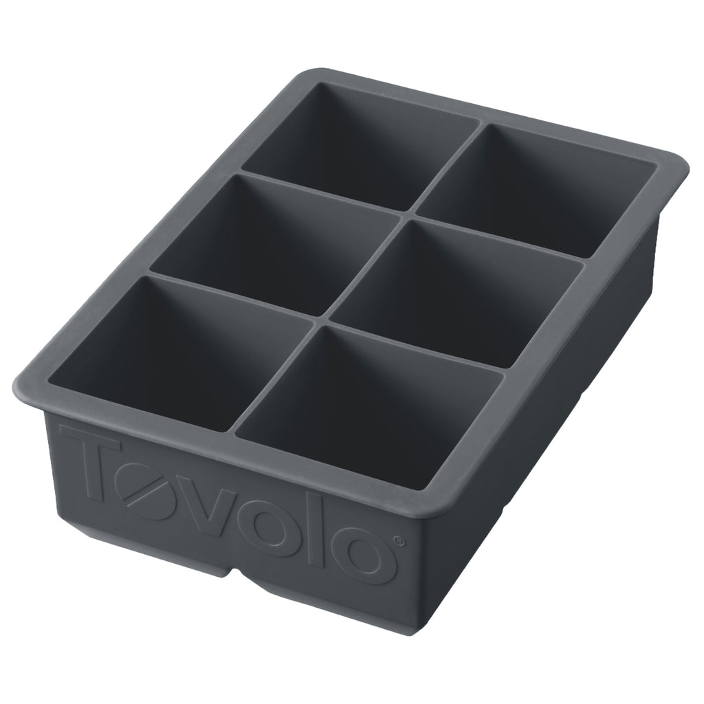 The King Cube Ice Mold is a black silicone tray with six large rectangular compartments, ideal for making big ice cubes. "Tovolo" is embossed on the side, making it a premium craft ice tray for any kitchen.