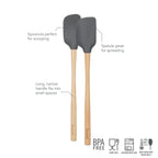 The tovolo Flex-Core Silicone Mini Spatula + Spoonula set features two BPA-free, food safe, dishwasher safe utensils with wooden handles and gray silicone heads—one mini spatula (right) for spreading and one spoonula (left) for scooping.