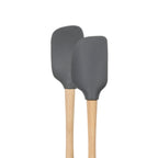The tovolo Flex-Core Silicone Mini Spatula + Spoonula set features two gray, heat-resistant utensils with light wooden handles—ideal for all your cooking or baking needs, displayed side by side against a white background.