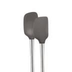 The tovolo Flex-Core Mini Spatula + Spoonula with Stainless Steel Handle in gray are side by side against a white background, featuring classic silicone designs ideal for mixing and scooping.