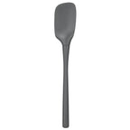 The Flex-Core Spoonula, shown in gray with a long handle and flat, flexible rectangular head, is an ergonomic silicone kitchen tool ideal for any cooking task, pictured against a plain white background.