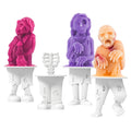 Three vibrant zombie-shaped frozen treats—red, purple, and orange—stand upright in Pop Molds white popsicle molds. An empty mold is placed in the slimline tray at the center.