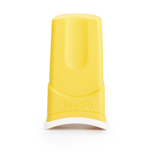 A yellow Butter Sleeve with a white base stands upright. "Tovolo" is embossed on the front, and its design resembles a mess-free butter applicator for easy, tidy use.