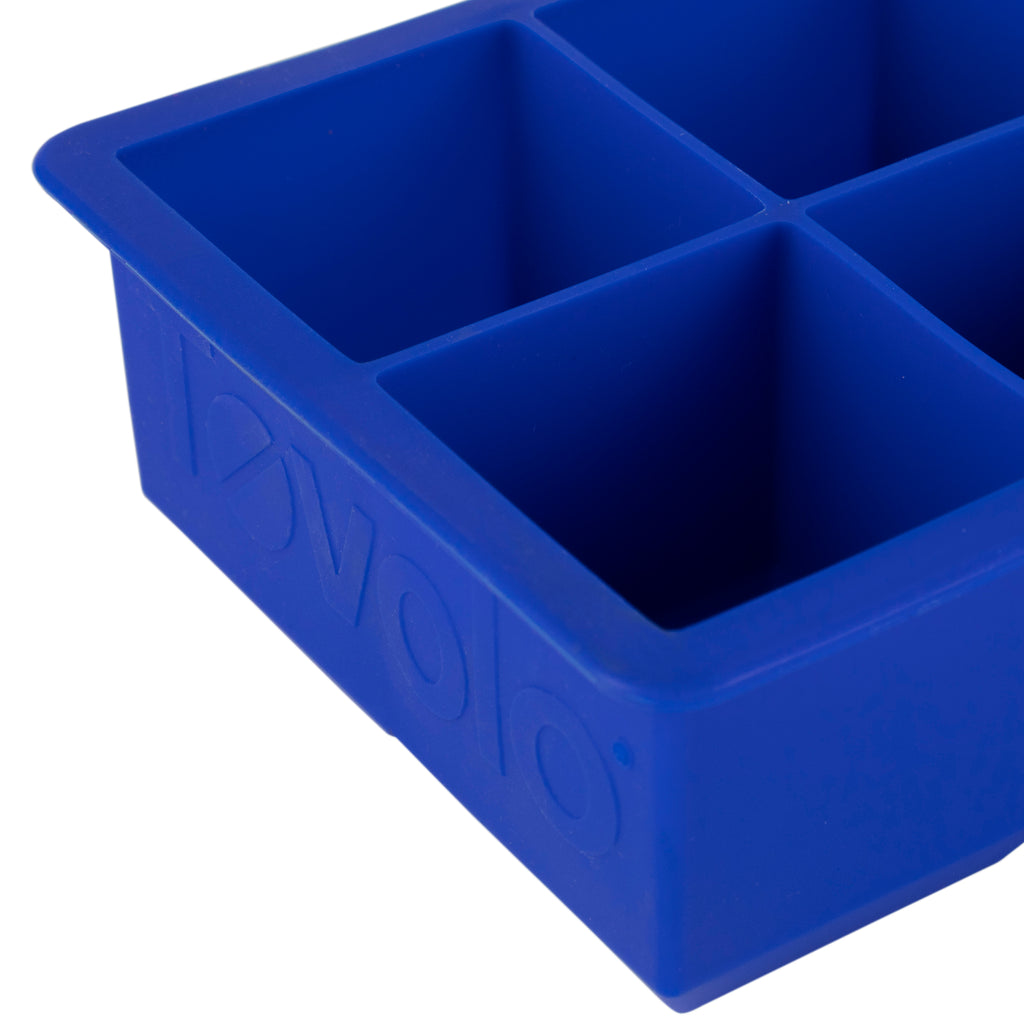 Close-up of a blue tovolo King Cube Silicone Ice Mold featuring four large square compartments for craft ice; the brand is embossed on the side. Set includes 2 trays.