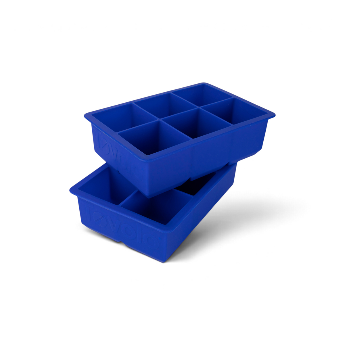 Two tovolo King Cube Silicone Ice Molds (Set of 2), each with six large square compartments, are stacked at an angle. The tovolo logo is embossed on the sides, ideal for making craft ice cubes at home.