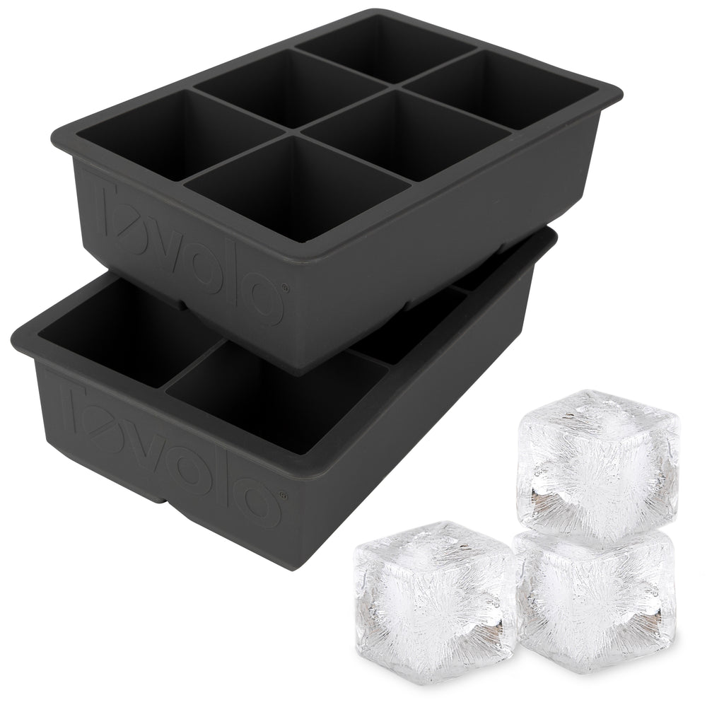 The tovolo King Cube Silicone Ice Molds (Set of 2) feature two black trays, each with six large square cavities—ideal for crafting impressive extra-large ice cubes at home.