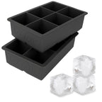 The tovolo King Cube Silicone Ice Molds (Set of 2) feature two black trays, each with six large square cavities—ideal for crafting impressive extra-large ice cubes at home.