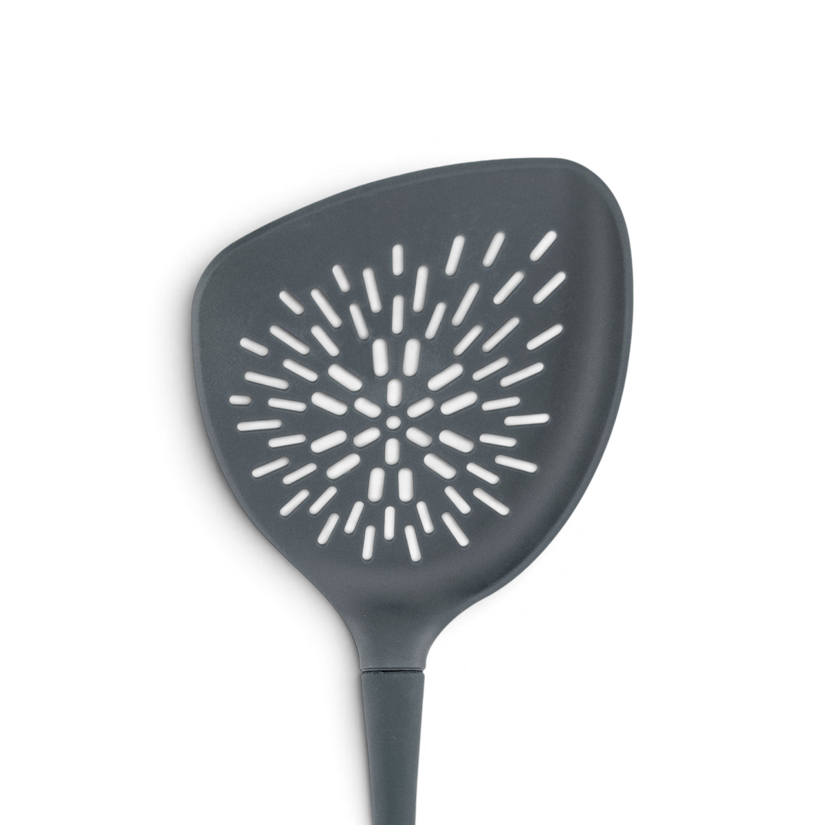 The Roasted Veggie Tool is a black non-stick spatula with a wide triangular head and sunburst-pattern holes for easy draining—ideal as a veggie turner when serving roasted vegetables.