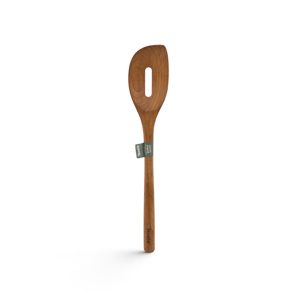 The Beechwood Utensils wooden slotted spoon features a long handle, an oval hole in the head—perfect for non-stick cookware—and a small green and white label at the neck.