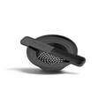 The Can Do Strainer is a black silicone drink strainer with a flat handle and round base, designed to fit over a glass and filter ice or fruit through small holes when pouring drinks.